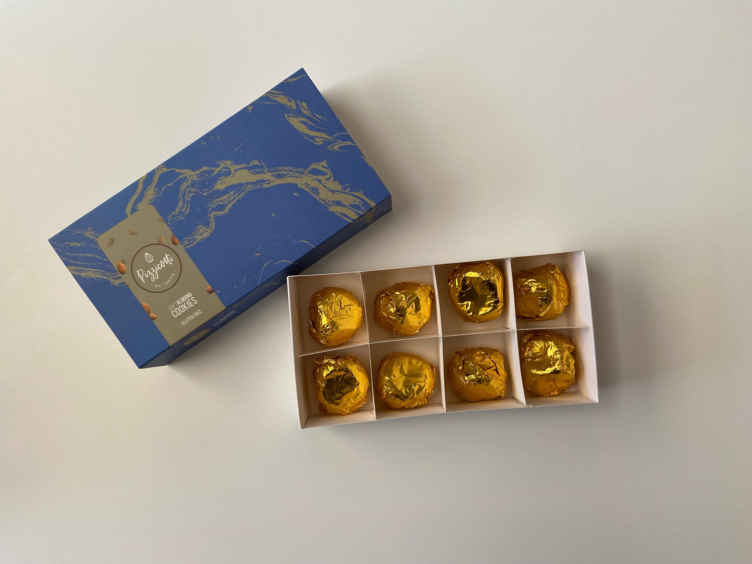 Pizzicotti in an open box, eight golden wrapped Pizzicotti per box